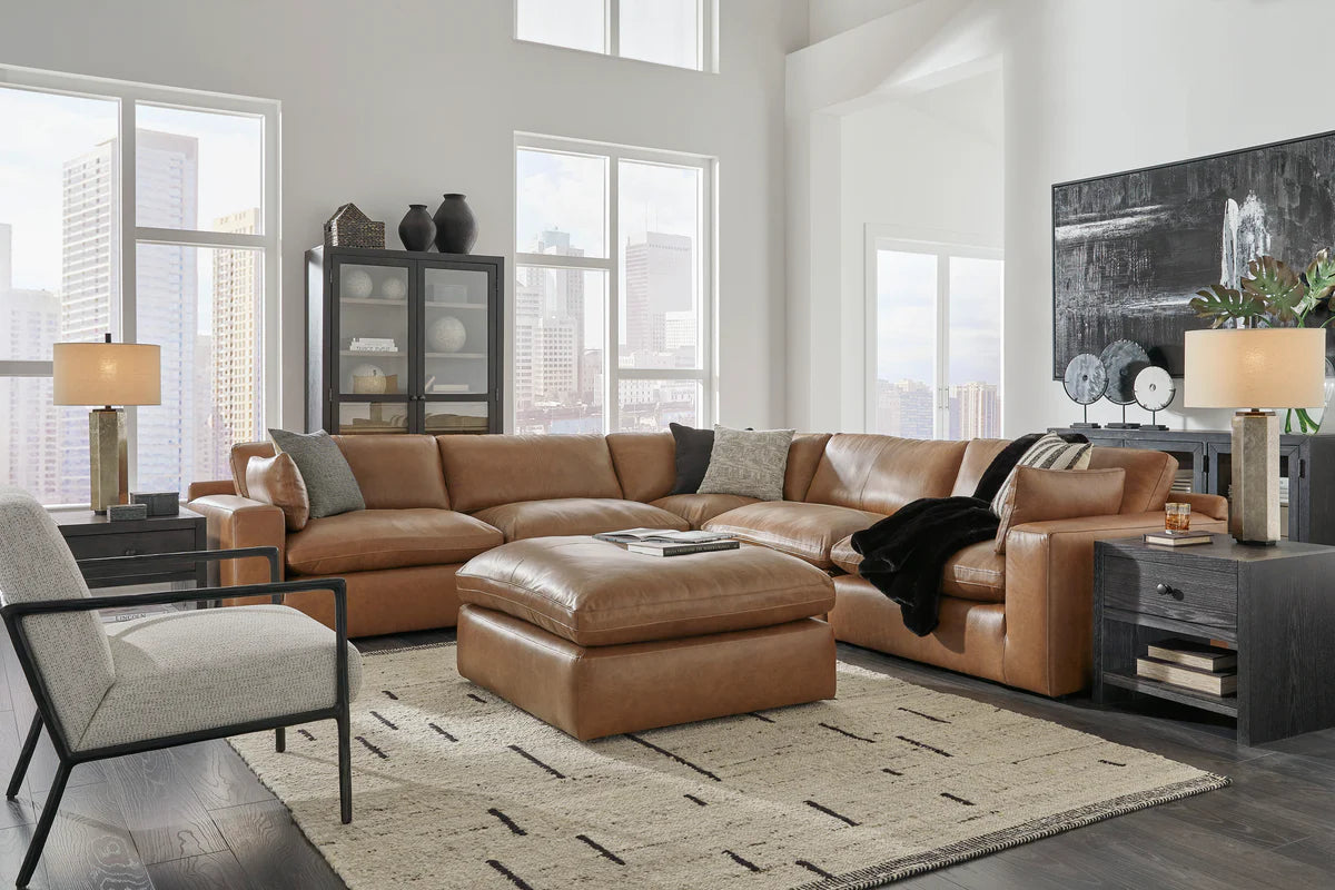 Brown leather sectional sofa with matching ottoman in a modern living room at Milwaukee Furniture.