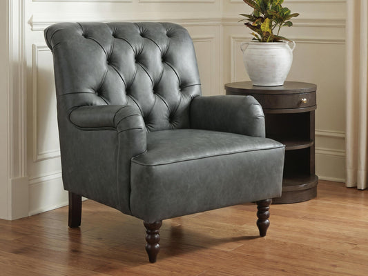 Gray tufted accent chair on a round living room rug