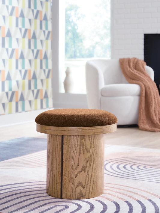 Round wooden stool with a brown cushioned seat in a living room