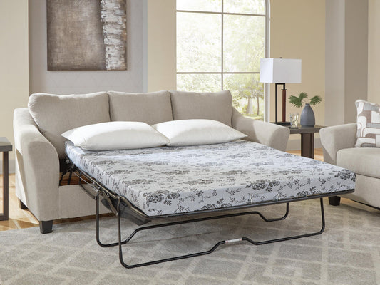 Beige sleeper sofa opened into a bed in a furnished living room