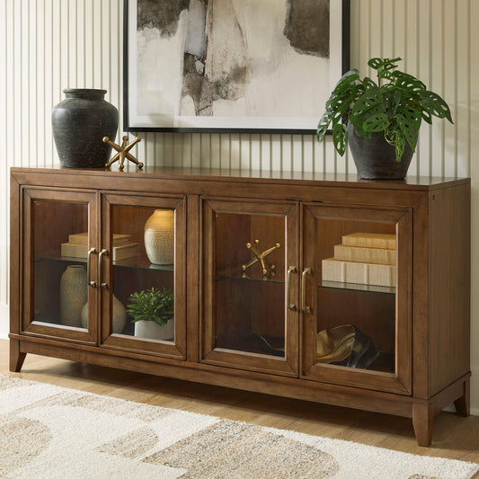 Brown glass-door cabinet beneath a mirror with plants and decorative objects