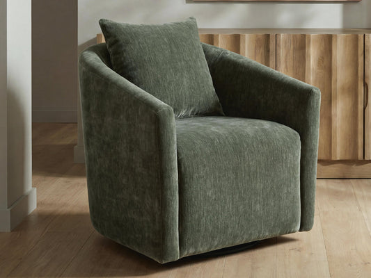 Dark green accent chair on a round rug beside a wooden cabinet