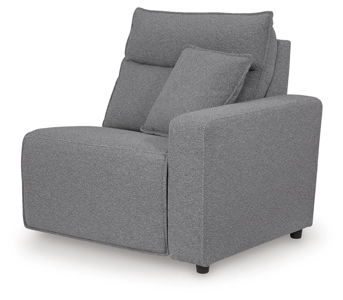 Gray upholstered sectional seat with one arm and an accent pillow