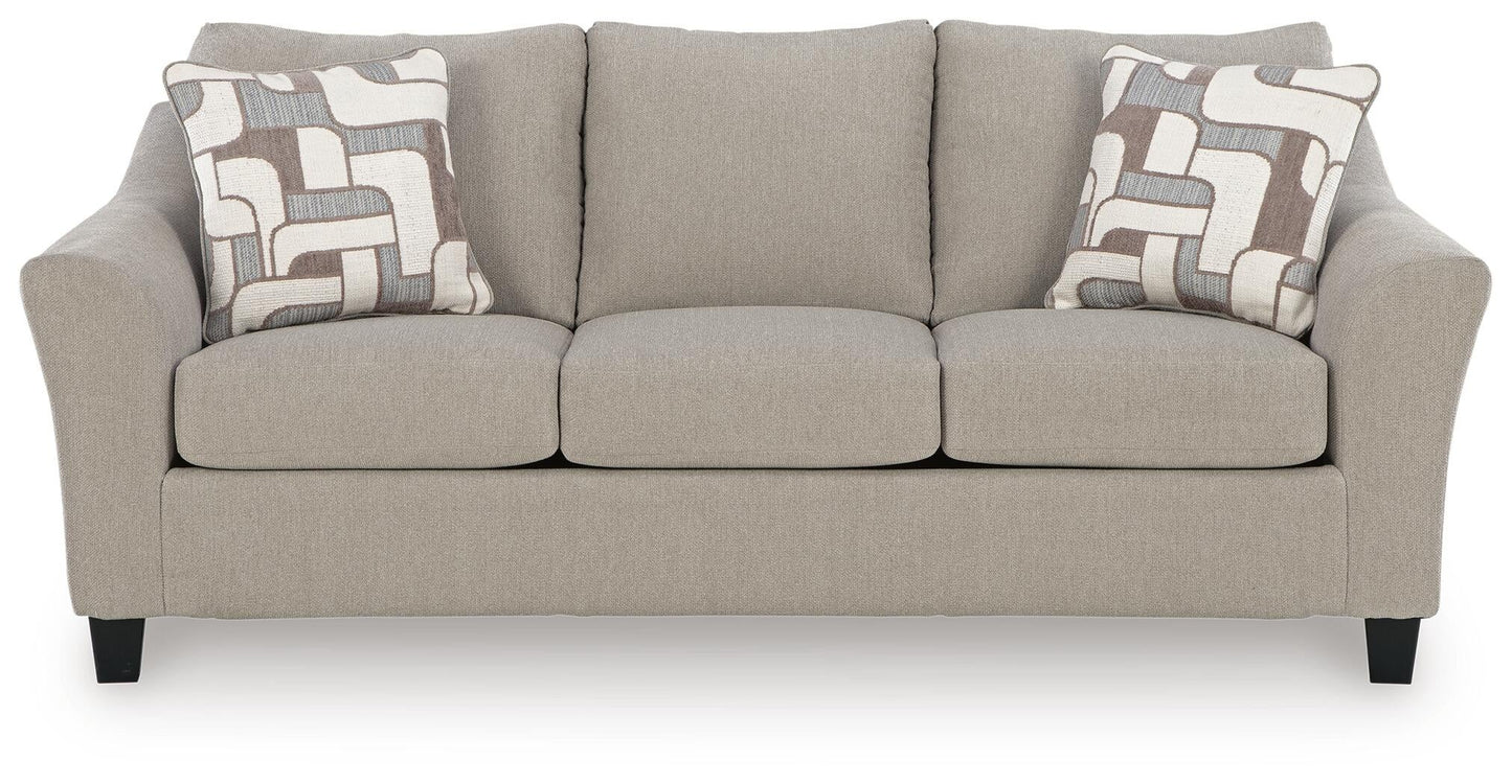 Beige loveseat with patterned accent pillows, front view