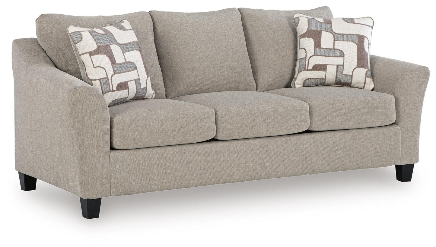 Beige loveseat with patterned accent pillows, angled view