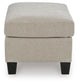 Beige upholstered ottoman with dark legs, end view